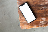 Top view mockup telephone device screen on a wooden table