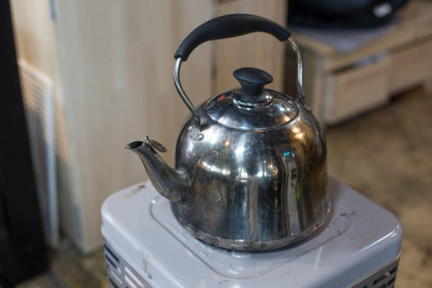 Stainless steel whistle kettle stands on a old stove