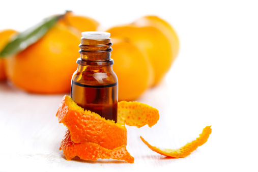 bottle of aromatic essence and fresh orange on white isolated background