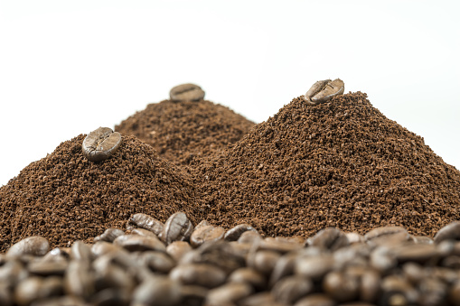 A Mountain of Ground coffee with half a Coffee bean on it