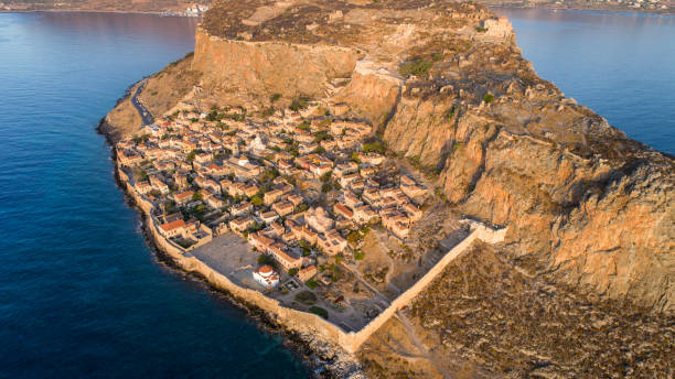 Monemvasia on Peloponnese, Greece Small settlement Monomvasia located on small rocky peninsula next to Peloponnese, Greece. Aerial view made with drone at morning, with soft sunlight monemvasia stock pictures, royalty-free photos & images