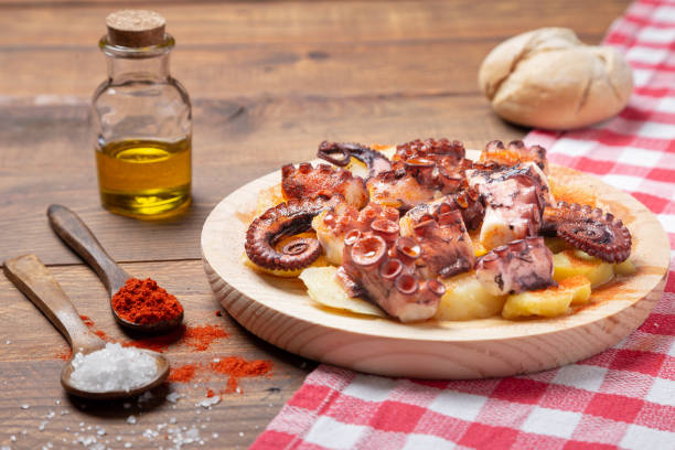 Pulpo a la gallega,galician octopus with ,potatoes paprika, salt and olive oil.  typical Spanish Galician tapa, on a traditional wooden plate. Tipical Spanish tapa concept. Pulpo a la gallega,galician octopus with ,potatoes paprika, salt and olive oil.  typical Spanish Galician tapa, on a traditional wooden plate. Tipical Spanish tapa concept. galicia stock pictures, royalty-free photos & images