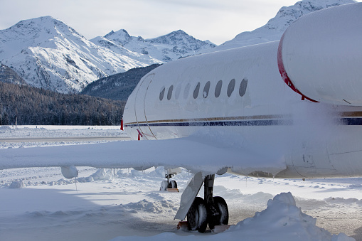 Commercial jet parked on the snow in the mountains.