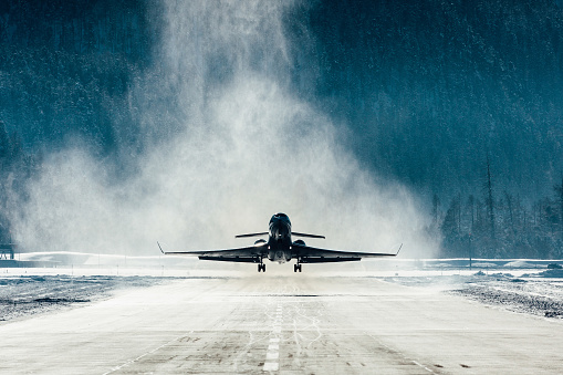 Commercial jet departing with snow blasting away