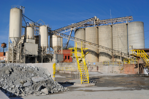 an industrial cement plant with silos and other machinery.