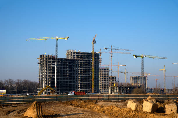 istock Tower cranes constructing a new residential building at a construction site against blue sky. 1197092397