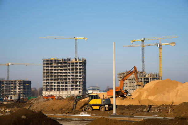 istock Excavator at a construction site on a background of a construction cranes and building. 1197093142