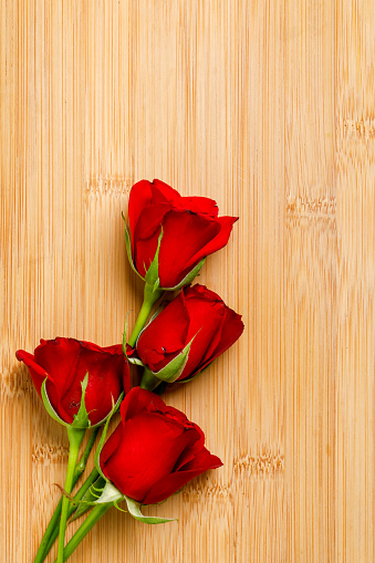 Red rose bunch and gift box on wooden board. Valentine day concept
