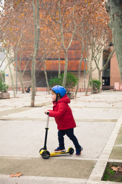 istock Little Boy riding on Scooter with helmet 1197094844
