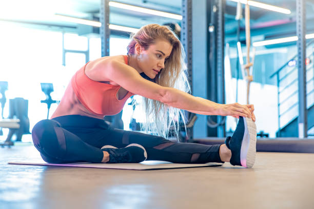 istock young pretty woman is stretching in the gym before exercise 1197099680