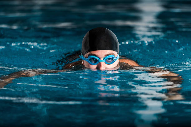 istock selective focus of athletic man in goggles training in swimming pool 1197099724