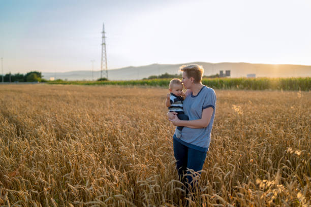 istock mother holding her baby on a wheat filed 1197101823