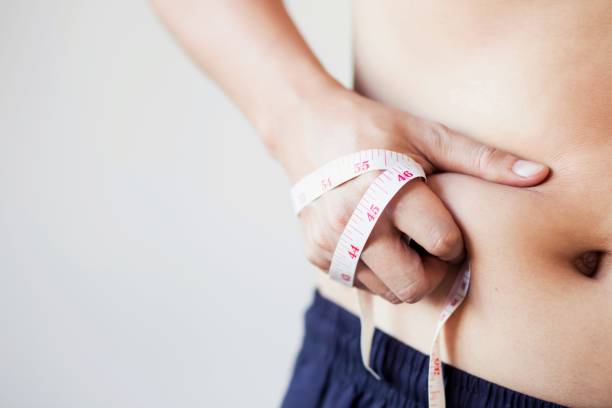 太った男は体重を減らし、食べ物をコントロールしたい - abdomen women waist slim ストックフォトと画像