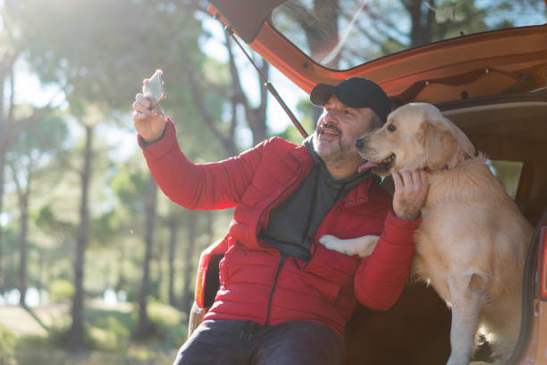 istock Smiling attractive mixed race man  taking selfie with his dog 1197104659
