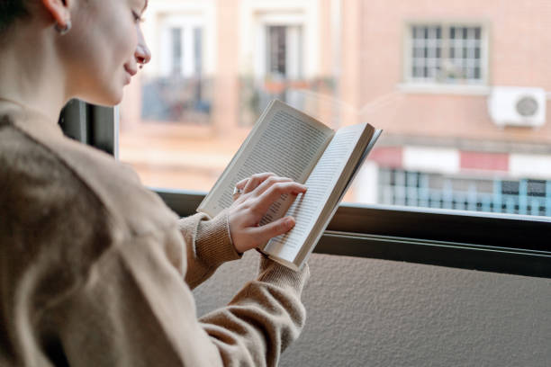 istock Young pretty woman reading a book 1197104700