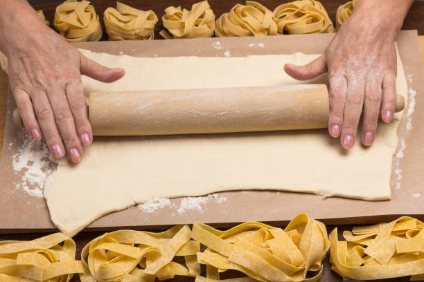 istock Hands roll out the dough with a rolling pin. 1197106390
