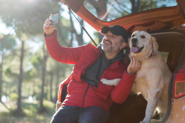 istock Man Making Selfie With His Dog on the car trunk 1197108440