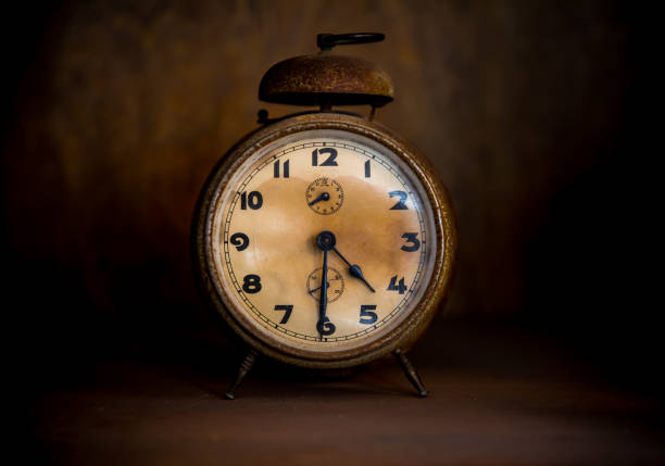 istock Old Alarm Table Clock on Wooden Shelf 1197109446