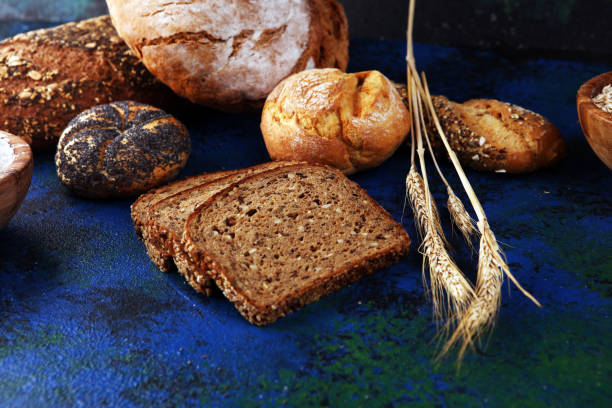 istock Assortment of baked bread and bread rolls and cutted bread on table background 1197110015