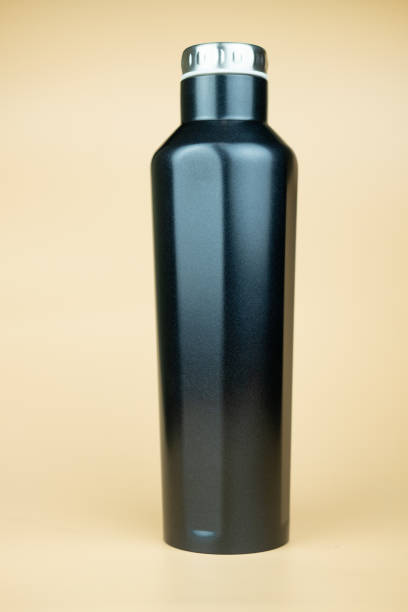 istock Stainless black thermos bottle for water on yellow background 1197111807