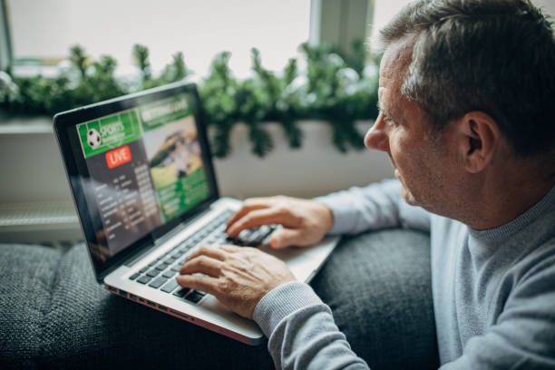 istock Watching football match on computer and betting 1197112288