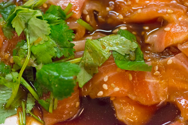 Salmon appetizer in soy sauce with herbs and sesame seeds