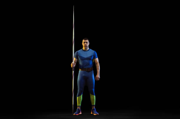 istock Male athlete practicing in throwing javelin isolated on black studio background in neon light 1197113243