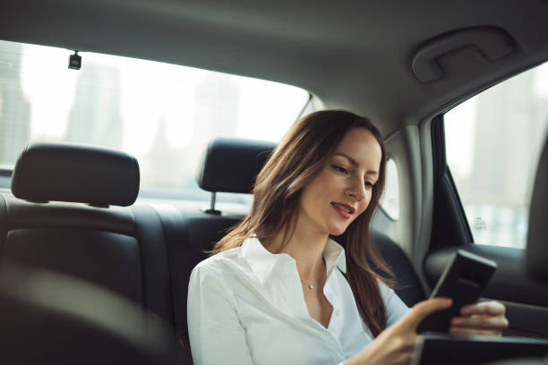 istock Businesswoman using smart phone in a car 1197114928