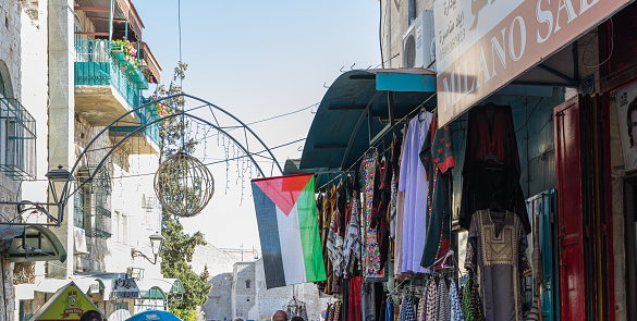 Jerusalem, Israel, December 28, 2018 : Palestinian flag hanging on a street with an oriental bazaar leading to the main square - Manger Square in Bethlehem in Palestine