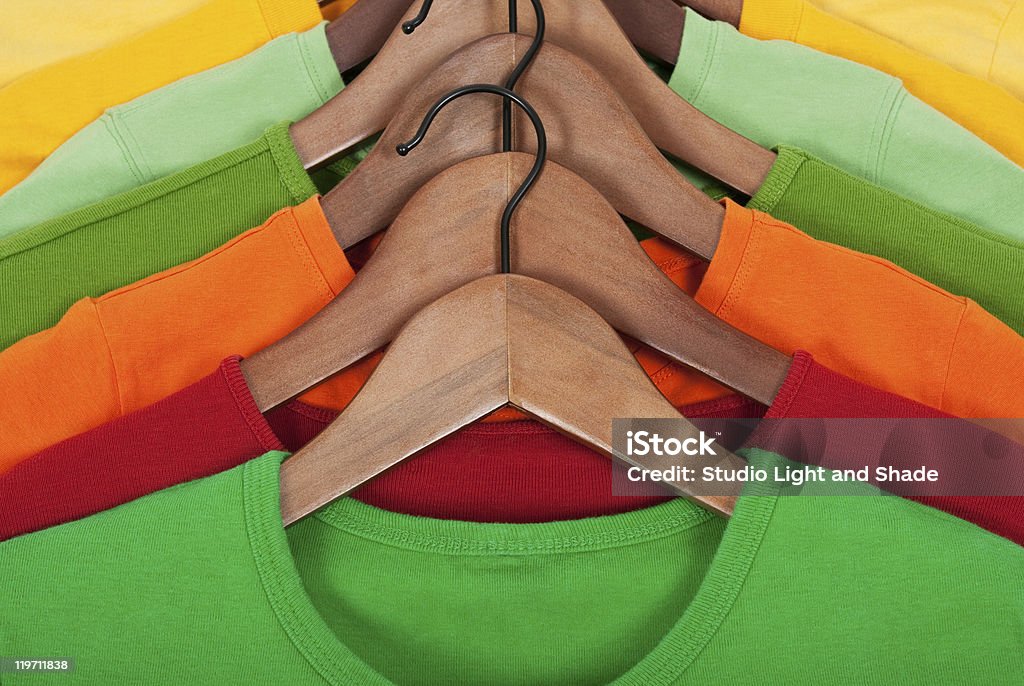 Des t-shirts sur cintres en bois - Photo de Cintre libre de droits