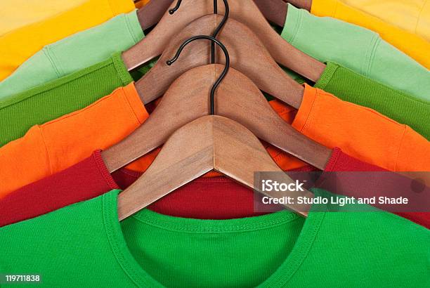 Tshirts Em Hangers De Madeira Brilhante - Fotografias de stock e mais imagens de Cabide - Objeto manufaturado - Cabide - Objeto manufaturado, Madeira - Material, Algodão