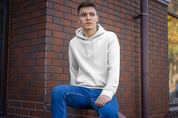 istock Design of a white hood on a young guy against a brick wall, front view. 1197120667