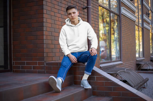 istock Mockup white hoodie on a young man against a brick wall. 1197120729