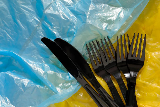 istock Black plastic cutlery lies on plastic bags 1197124345