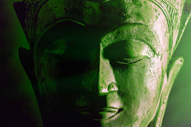 istock Spiriitual enlightenment. Green buddha face statue close-up. Bold graphic image 1197130273