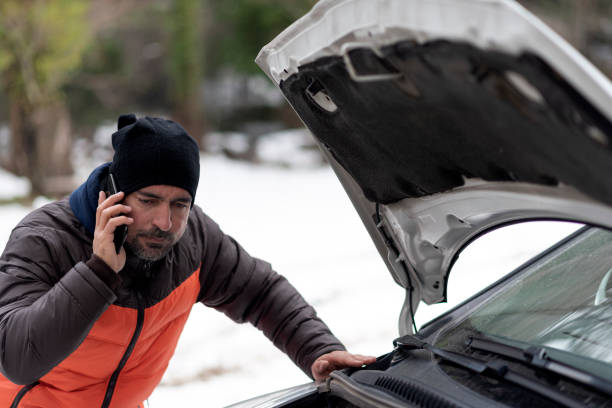 A roadside scene depicting a car with a technical issue being assisted by a towing vehicle, with warning triangles set up for safety