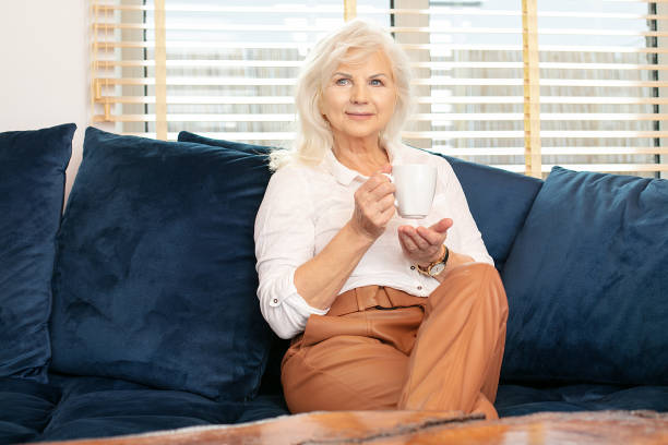 femme aîné de sourire buvant le café à la maison - 16611 photos et images de collection