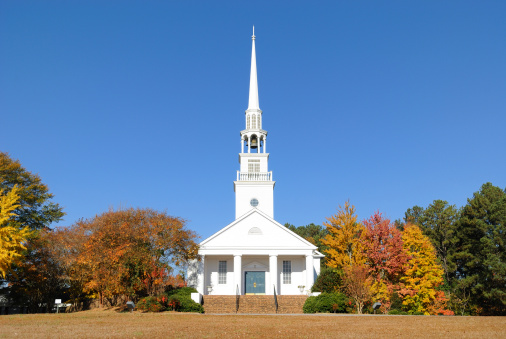 Warwick, United States – October 18, 2022: A back view of a church surrounded by autumn trees on a bright day in Warwick village, New York, United States