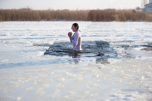 Epiphany.Bathing in the ice hole at the baptism of the Lord. A woman is dipped in cold water