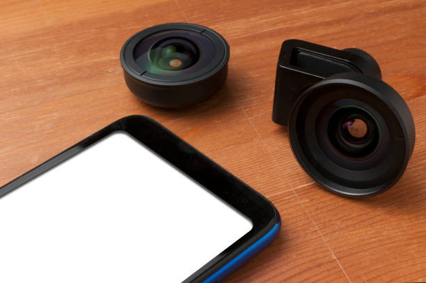 Blank screen smartphone on wooden table with some add on lenses