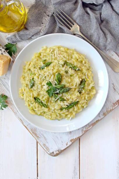 istock Italian risotto with spring asparagus and parmesan cheese in plate on light background. 1197141341