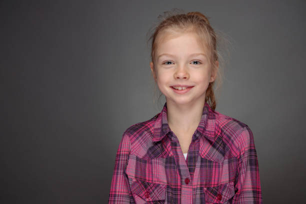 smiling girl in purple shirt looking straight at camera stock photo