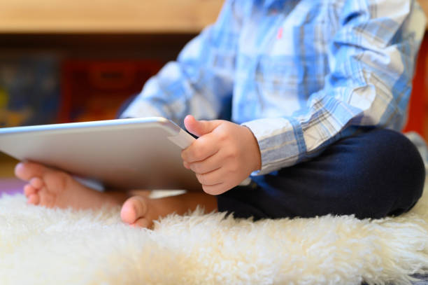 istock a little boy holds a tablet in his hands 1197145629