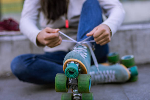 Unrecognizable  woman putting her quads skates in the street Unrecognizable woman putting her quads skates in the street roller skating stock pictures, royalty-free photos & images