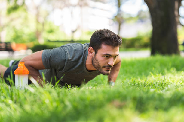 Young man doing push-up exercises in the park