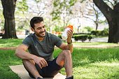 Young man making a protein shake in the park