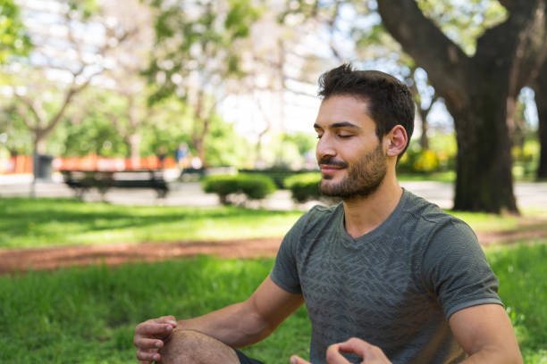 istock Muscular young man doing yoga in a public park 1197151985