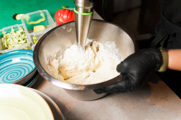 istock Chef making cheese mix for cheese pancake at restaurant. Blender whips the cottage cheese. Cheesecake preparing. 1197154816