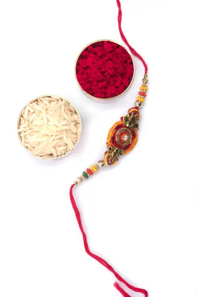 Indian festival: Raksha Bandhan background with an elegant Rakhi on a white background. A traditional Indian wrist band which is a symbol of love between Brothers and Sisters
