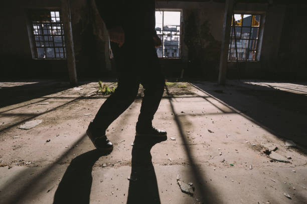 istock Footsteps of man sneak inside some large, dark, spooky,abandoned building 1197158461